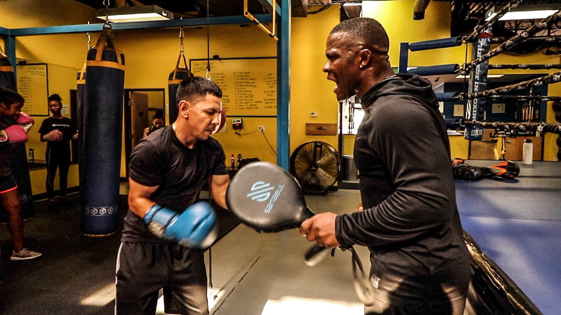 Coach Hector Saez doing mitt work with a fighter at Bring It Back Boxing gym in Denver